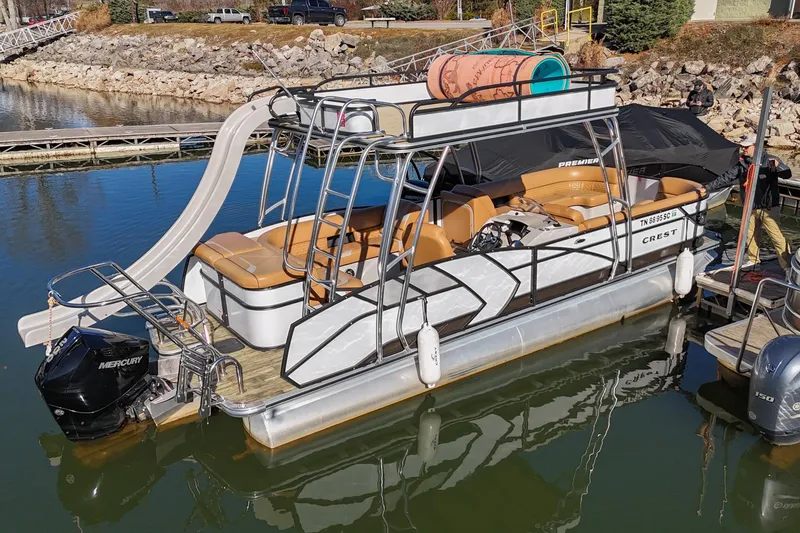Slide: The Image of 2023 Crest Caribbean LX 250 pontoon boat with slide, docked on calm water. - 5