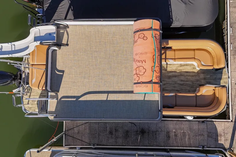 Slide: The Image of 2023 Crest Caribbean LX 250 pontoon boat with slide and tan seating, docked. - 7