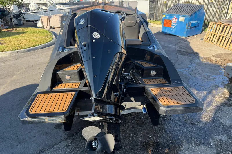 Slide: The Image of 2023 D-Boat Diamond 550 with sleek black design and wooden accents, docked outdoors. - 6