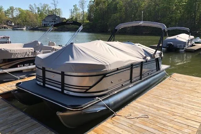 Slide: The Image of 2020 Starcraft SLS 3 pontoon boat docked with cover on a sunny day. - 1