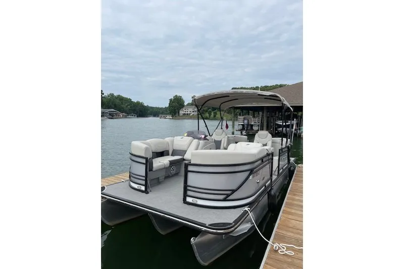 Slide: The Image of 2020 Starcraft SLS 3 pontoon boat docked on a serene lake. - 2