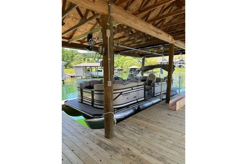 Slide: The Image of 2020 Starcraft SLS 3 pontoon boat docked under wooden shelter. - 3