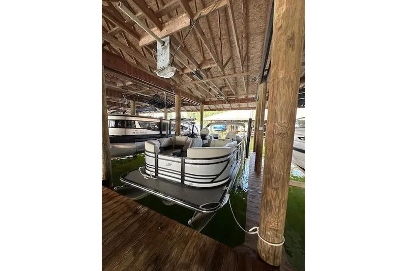 Slide: The Image of 2020 Starcraft SLS 3 pontoon boat docked under wooden shelter. - 9