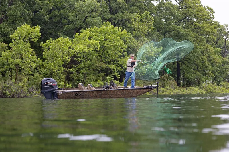 Slide: The Image of Man casting net from 2026 G3 Sportsman 1710 boat on a lake, surrounded by trees. - 20