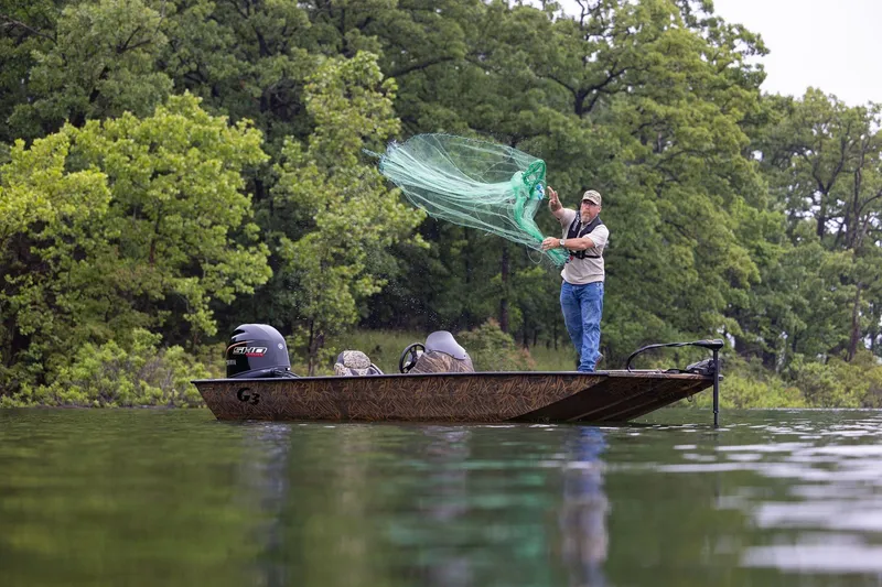 Slide: The Image of Man casting net from 2026 G3 Sportsman 1710 boat on a lake. - 21