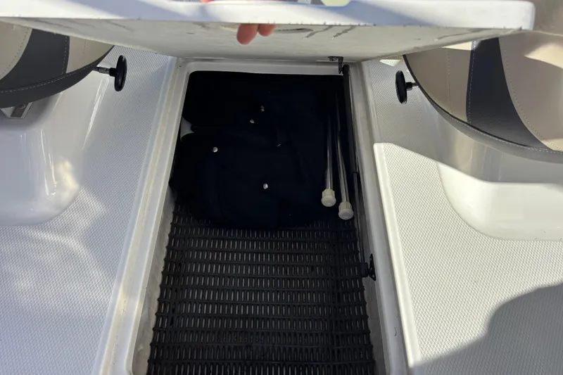 Slide: The Image of 2015 Chaparral 19 H2O Ski & Fish boat storage compartment with open lid. - 16