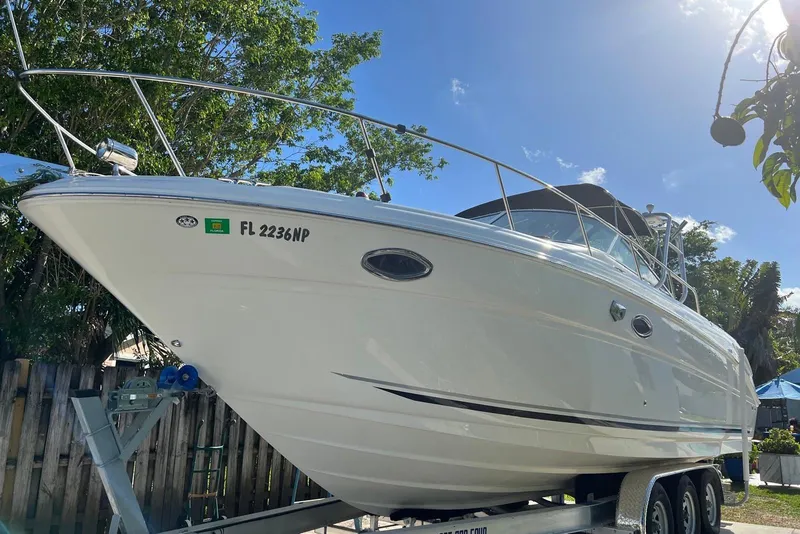 Slide: The Image of 2007 Sea Ray 270 Amberjack boat on trailer, sunny day, trees in background. - 12