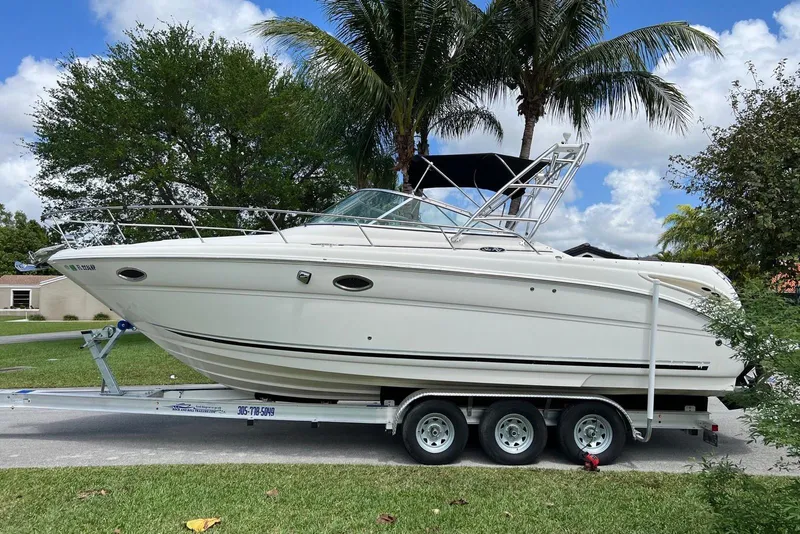 Slide: The Image of 2007 Sea Ray 270 Amberjack boat on trailer, surrounded by palm trees and blue sky. - 4