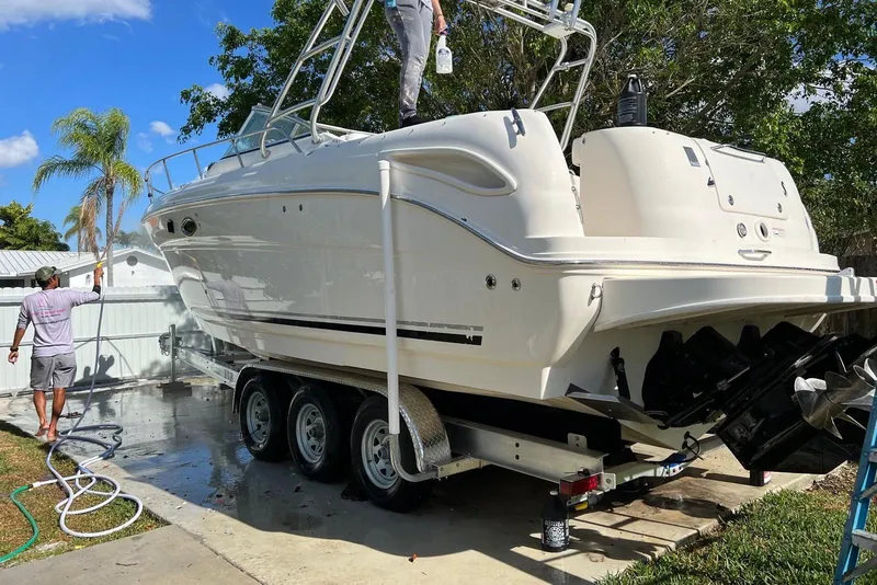Slide: The Image of 2007 Sea Ray 270 Amberjack boat being cleaned on a trailer in a sunny yard. - 6