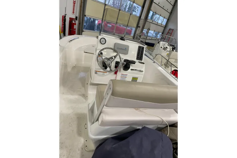 Slide: The Image of 2019 Robalo R160 Center Console boat interior with steering wheel and Garmin equipment. - 2