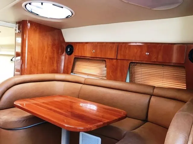 Slide: The Image of Interior of a 2006 Four Winns 328 Vista yacht with wooden table and leather seating. - 18