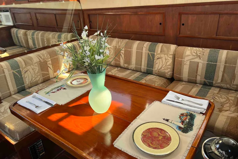 Slide: The Image of Cozy dining area in 1980 Wellington 44 Cutter Center Cockpit with floral decor and elegant table setting. - 12