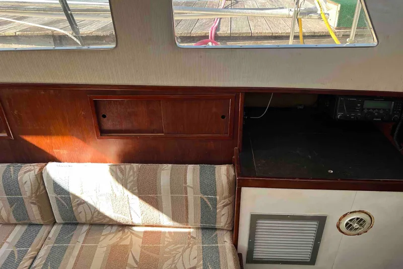 Slide: The Image of Interior of 1980 Wellington 44 Cutter Center Cockpit with wood paneling and patterned seating. - 15