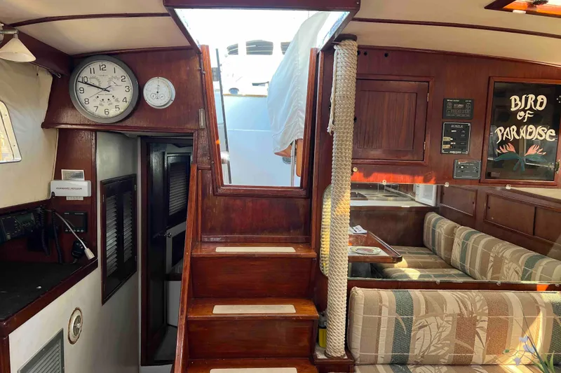 Slide: The Image of Interior of 1980 Wellington 44 Cutter Center Cockpit with wooden stairs and cozy seating area. - 18