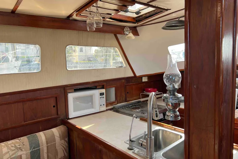 Slide: The Image of Interior of 1980 Wellington 44 Cutter Center Cockpit with kitchen and wooden finishes. - 22