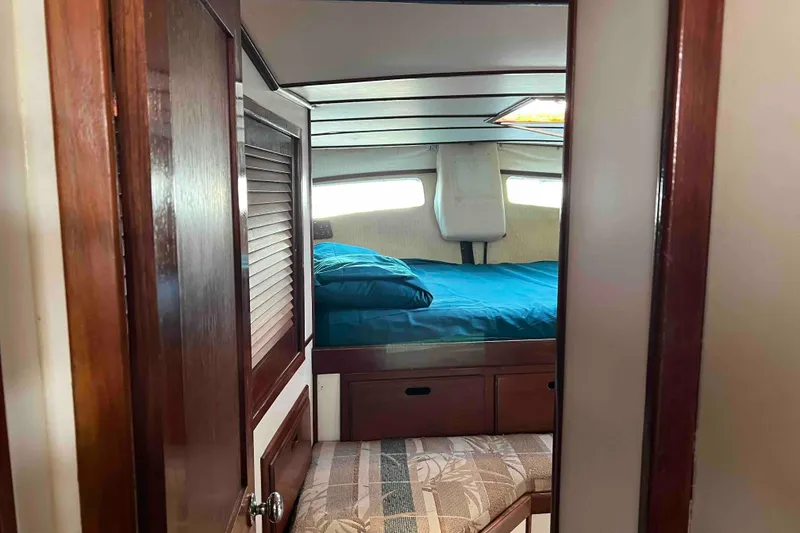Slide: The Image of Interior cabin of 1980 Wellington 44 Cutter Center Cockpit with wooden finish and blue bedding. - 36