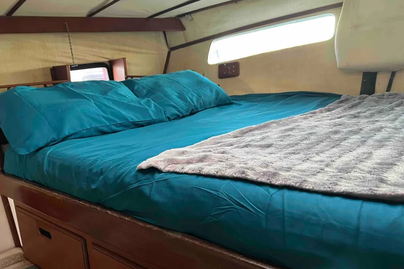Slide: The Image of Cozy cabin interior of 1980 Wellington 44 Cutter Center Cockpit with teal bedding. - 39