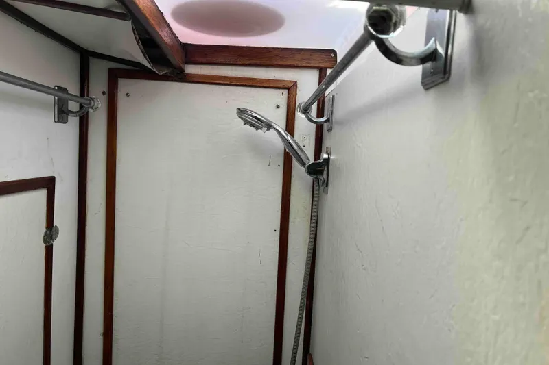 Slide: The Image of Interior of 1980 Wellington 44 Cutter Center Cockpit shower area with wooden trim. - 43