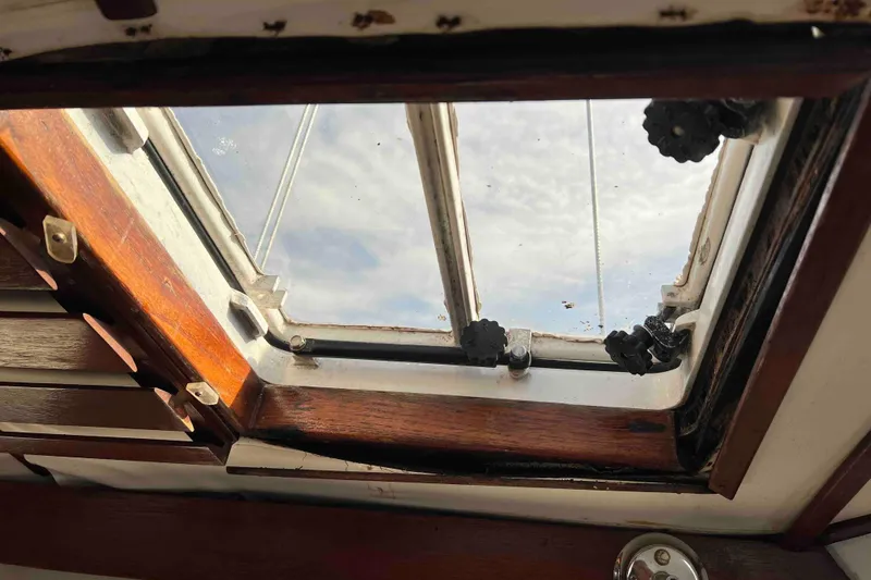 Slide: The Image of Skylight view from 1980 Wellington 44 Cutter Center Cockpit, showcasing wooden frame and sky. - 46