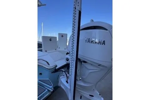 Slide: The Image of 2024 Pathfinder 2500 Hybrid boat with center console and T-top in a marina setting. - 3