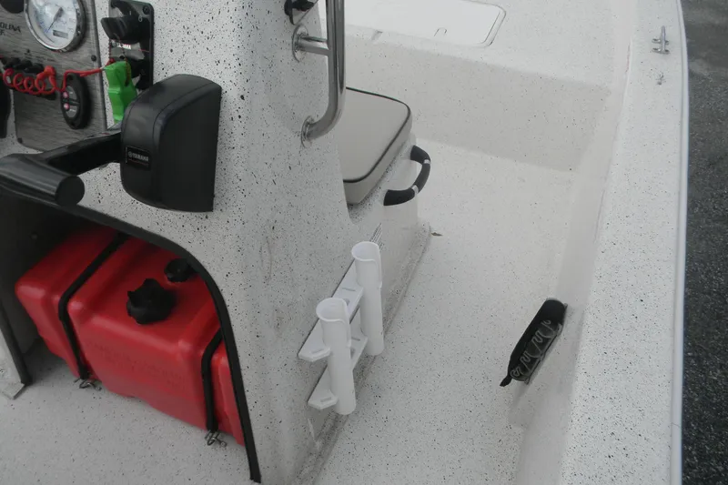 Slide: The Image of 2024 Carolina Skiff e-18 boat interior with console, fuel tanks, and rod holders. - 4