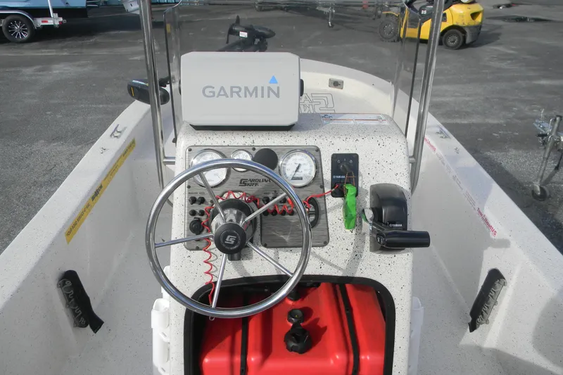 Slide: The Image of 2024 Carolina Skiff e-18 boat dashboard with Garmin navigation system and steering wheel. - 6