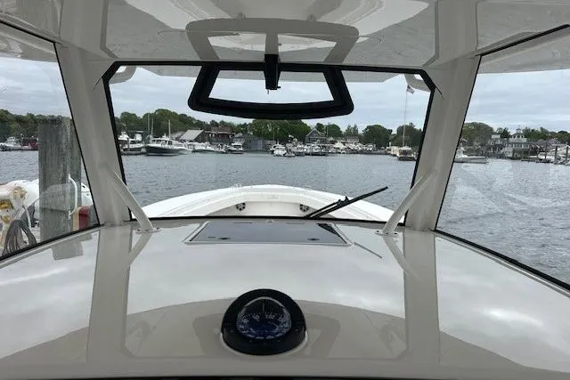 Slide: The Image of 2022 Regulator 41 boat cockpit view, overlooking marina with calm waters and docked boats. - 15