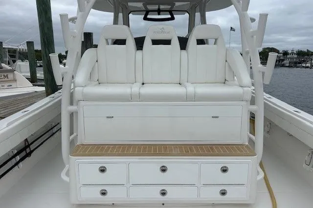 Slide: The Image of 2022 Regulator 41 boat with white seating and storage drawers, docked by the water. - 27