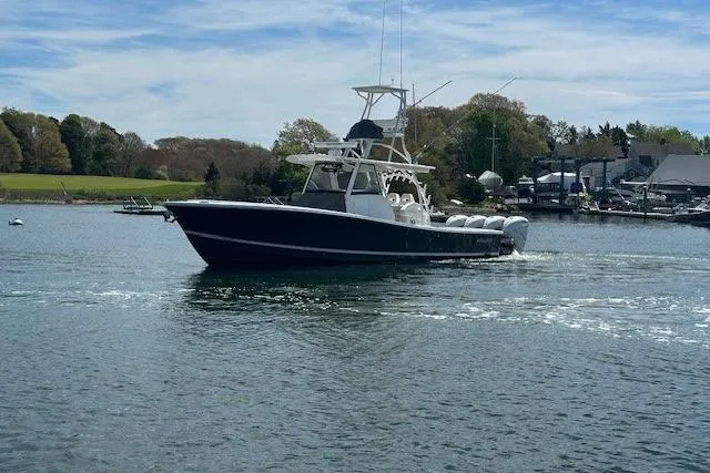 Slide: The Image of 2022 Regulator 41 boat cruising on a calm lake with scenic background. - 3