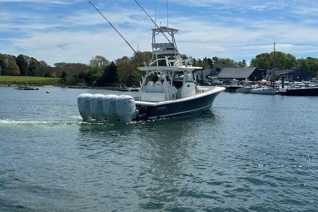 Slide: The Image of 2022 Regulator 41 boat with multiple engines cruising in a scenic harbor. - 5