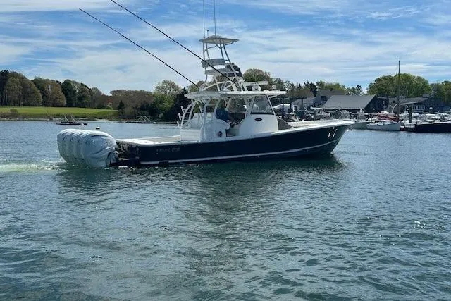 Slide: The Image of 2022 Regulator 41 boat cruising on a calm lake with scenic background. - 6