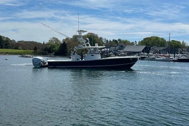 Slide: The Image of 2022 Regulator 41 boat cruising on a calm lake under a clear blue sky. - 7
