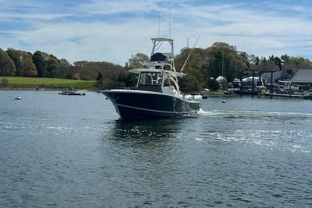Slide: The Image of 2022 Regulator 41 boat cruising on a scenic lake with trees in the background. - 8