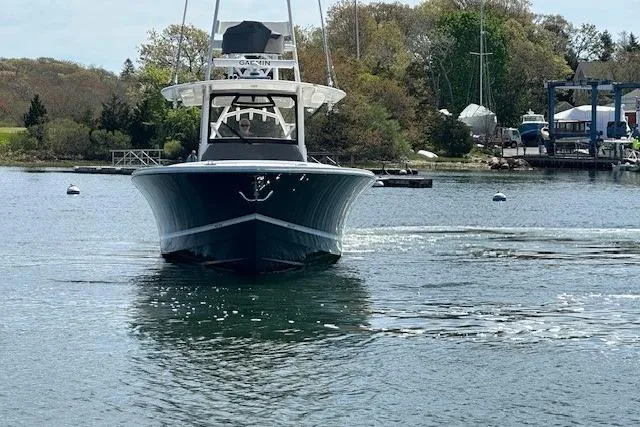 Slide: The Image of 2022 Regulator 41 boat on calm water, surrounded by trees and docks. - 9