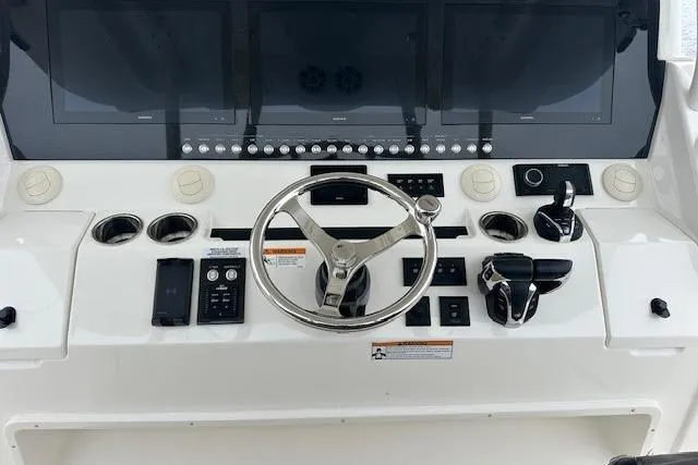 Slide: The Image of 2022 Regulator 41 boat dashboard with steering wheel and control panel. - 14