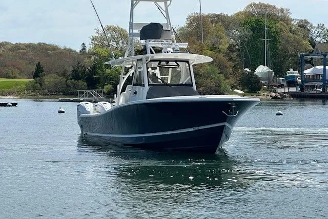 Slide: The Image of 2022 Regulator 41 boat cruising on a calm lake with trees in the background. - 11