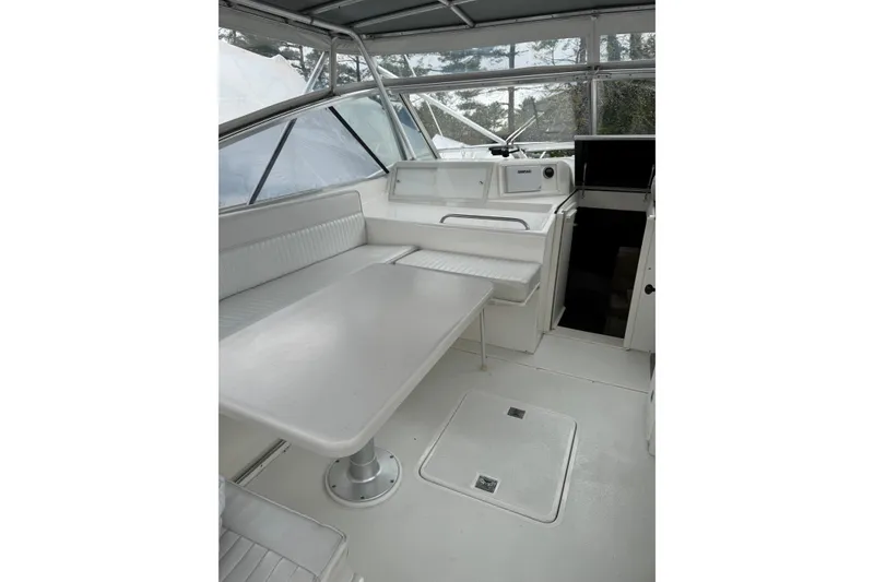 Slide: The Image of Interior of 1993 Blackfin 38 Combi boat with white seating and table. - 6