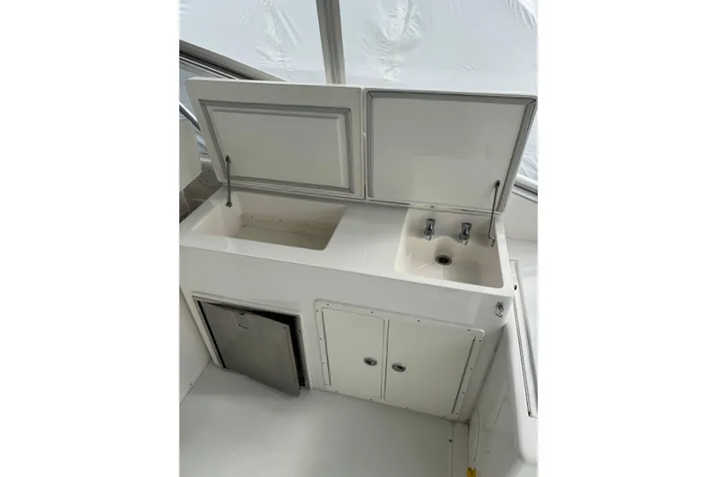 Slide: The Image of 1993 Blackfin 38 Combi boat galley with sink, storage, and compact refrigerator. - 8