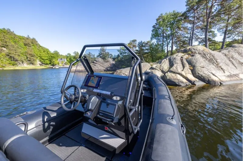 Slide: The Image of Highfield Patrol 700 boat 2026 on calm lake with rocks. - 6