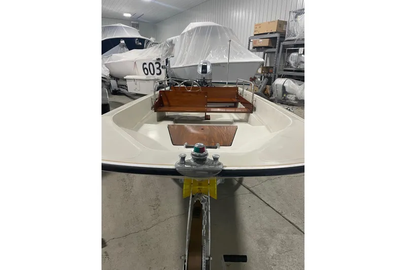 The Image of 1986 Boston Whaler 150 Super Sport boat in storage, showcasing interior and steering console. - 1
