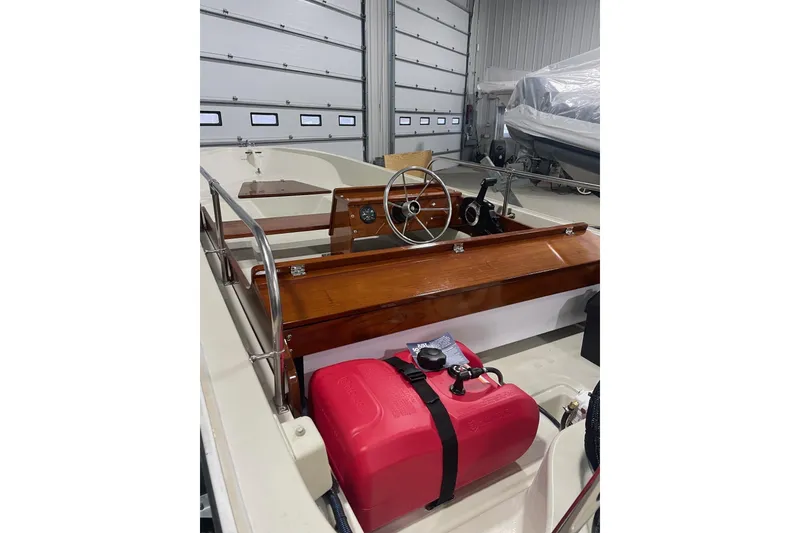 Slide: The Image of 1986 Boston Whaler 150 Super Sport boat interior with wooden dashboard and red fuel tank. - 5
