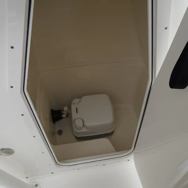 Slide: The Image of 2025 Cobia 220 Center Console boat interior with compact marine toilet. - 10