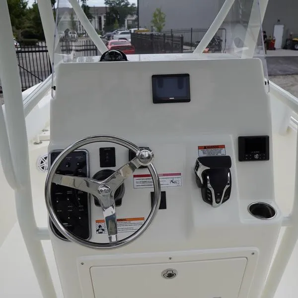 Slide: The Image of 2025 Cobia 220 Center Console boat dashboard with steering wheel and controls. - 7