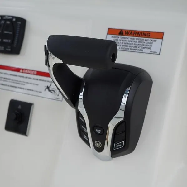Slide: The Image of Throttle control of 2025 Cobia 220 Center Console boat with warning labels. - 9