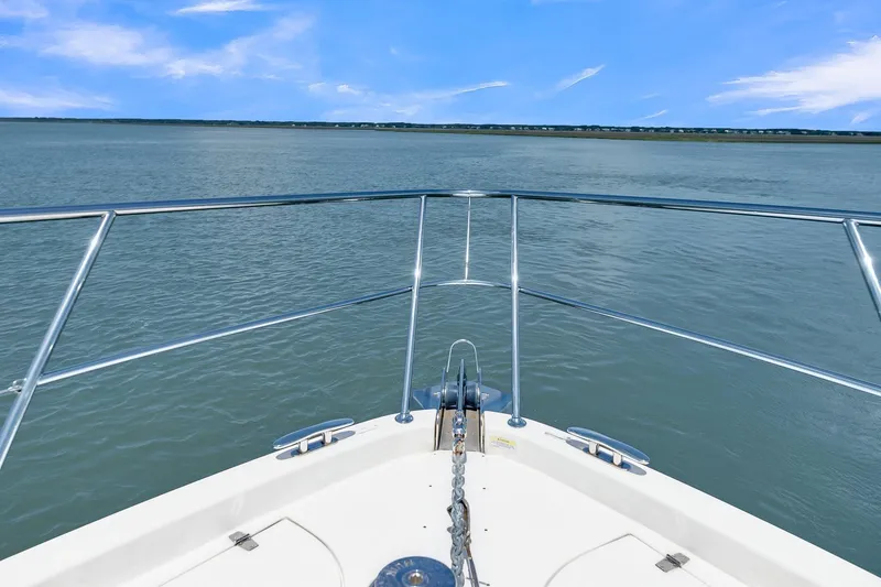 Slide: The Image of Bow view of 2020 Riviera 4800 Sport Yacht on calm waters under blue sky. - 10