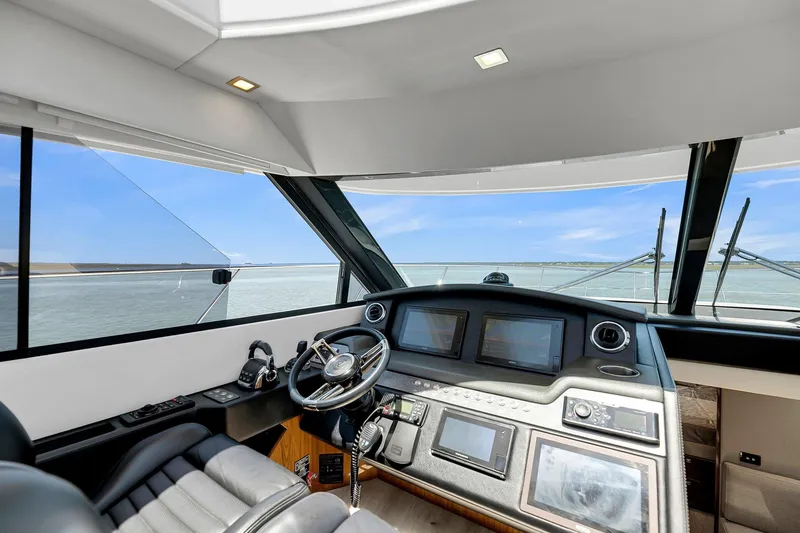 Slide: The Image of Interior view of 2020 Riviera 4800 Sport Yacht helm with modern navigation equipment. - 31