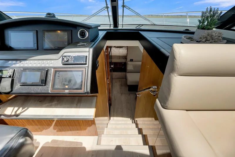 Slide: The Image of Interior view of 2020 Riviera 4800 Sport Yacht helm with navigation controls and seating. - 32