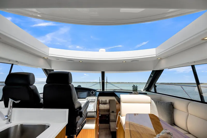Slide: The Image of Interior view of 2020 Riviera 4800 Sport Yacht with panoramic windows and luxurious seating. - 33