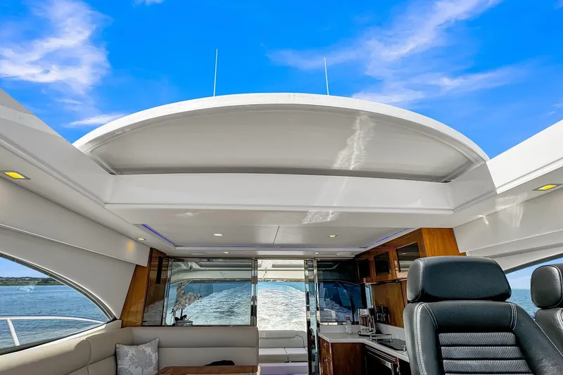 Slide: The Image of Interior view of 2020 Riviera 4800 Sport Yacht with open roof and ocean backdrop. - 34