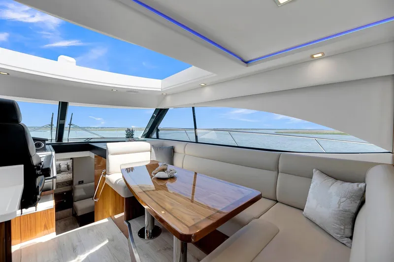 Slide: The Image of Luxurious interior of 2020 Riviera 4800 Sport Yacht with panoramic windows and elegant seating. - 36